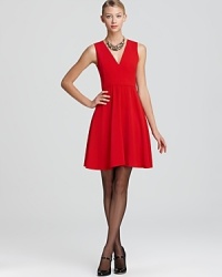 An A-line silhouette equipped with a double v neckline lends feminine flair to a crepe DKNY dress.