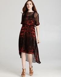 An elongated back hem lends dramatic flair to this flowing Sam & Lavi dress, emblazoned with a bold abstract print. An elongated back hem lends dramatic flair to this flowing Sam & Lavi dress, emblazoned with a bold abstract print.