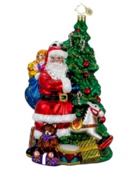 The epitome of holiday cheer. Santa Claus stops unloading gifts to smile beside a beautifully decorated Christmas Tree in this elaborately hand-painted ornament from Christopher Radko. The epitome of holiday cheer. Santa Claus stops unloading gifts to smile beside a beautifully decorated Christmas Tree in this elaborately hand-painted ornament from Christopher Radko.