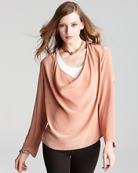 This flowing Eileen Fisher draped silk shirt lets you choose the length of your sleeves with an adjustable buttoned roll tab. This flowing Eileen Fisher draped silk shirt lets you choose the length of your sleeves with an adjustable buttoned roll tab.