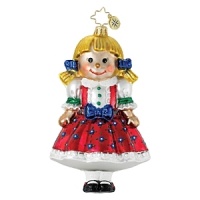 A Christmas doll ornament shines in a bright red jumper and blue bows.