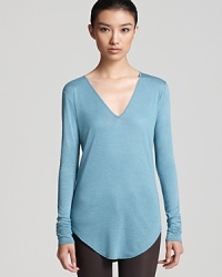 This Helmut Lang v neck top updates your staple collection with cool, flowing over your silhouette with ease and rounding out with a curved hem. This Helmut Lang v neck top updates your staple collection with cool, flowing over your silhouette with ease and rounding out with a curved hem.