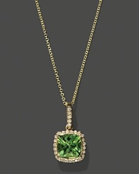 Diamonds frame a faceted peridot, set in 14K yellow gold. Diamonds frame a faceted peridot, set in 14K yellow gold.