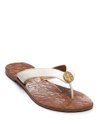 A simple accessory for the beach or walking comfortably around the city; you won't want to wear anything else. Signature embossed leather footbed and metallic signature logo medallion on center of patent strap. A simple accessory for the beach or walking comfortably around the city; you won't want to wear anything else. Signature embossed leather footbed and metallic signature logo medallion on center of patent strap.