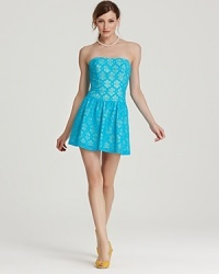 Showcasing this season's color trend, this Lilly Pulitzer dress flaunts a turquoise silhouette springing with floral cutouts. Showcasing this season's color trend, this Lilly Pulitzer dress flaunts a turquoise silhouette springing with floral cutouts.
