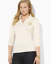 Sleek gold-toned buttons and a metallic embroidered crest lend regal elegance to a soft cotton polo shirt. Sleek gold-toned buttons and a metallic embroidered crest lend regal elegance to a soft cotton polo shirt.