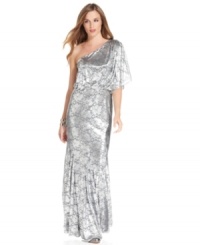 Adrianna Papell starts with a feminine, lacy gown silhouette and adds a shimmering metallic finish to make it completely mesmerizing. Adrianna Papell starts with a feminine, lacy gown silhouette and adds a shimmering metallic finish to make it completely mesmerizing.