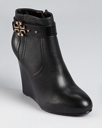 Atop a wedge heel, Tory Burch's Elina bootie is updated with a pin-strap detail at the ankle and a requisite logo in gleaming golden hardware. Atop a wedge heel, Tory Burch's Elina bootie is updated with a pin-strap detail at the ankle and a requisite logo in gleaming golden hardware.