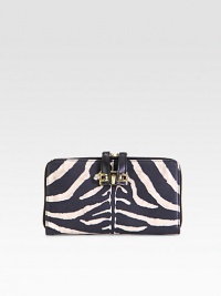 Luxurious zebra-print leather with radiant hardware and secured zipper pulls.Two-way zip-around closureSecured zipper pullsOne inside zip pocketTwo open compartmentsTwelve credit card slotsTwo bill compartmentsFully lined7½W X 4¼H X 1DMade in Italy