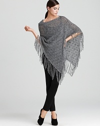 Craft a striking silhouette in a DKNY poncho emboldened by a dramatic cascade of fringed trim. Slip the statement style over monochrome separates for bohemian edge. Craft a striking silhouette in a DKNY poncho emboldened by a dramatic cascade of fringed trim. Slip the statement style over monochrome separates for bohemian edge.