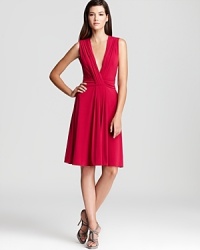 Paint the town red in this fiery-hued Armani Collezioni dress with dramatic plunging neckline. A split back adds to the allure, ensuring statement style. Paint the town red in this fiery-hued Armani Collezioni dress with dramatic plunging neckline. A split back adds to the allure, ensuring statement style.