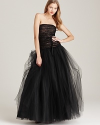 An extravagant skirt of gauzy tulle is crowned with an intricately ruched bodice on this ML Monique Lhuillier strapless gown. A wispy ribbon at the waist completes this stunning evening look. An extravagant skirt of gauzy tulle is crowned with an intricately ruched bodice on this ML Monique Lhuillier strapless gown. A wispy ribbon at the waist completes this stunning evening look.