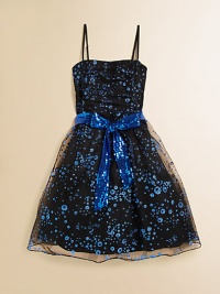 She'll be the belle of the ball in this shimmering, sparkly frock with sequined sash tie and tulle lining.Straight necklineSleeveless with adjustable spaghetti strapsBack zipperWaistband with sequin sashFull skirtFully linedPolyester/nylonDry cleanMade in the USA of imported fabric