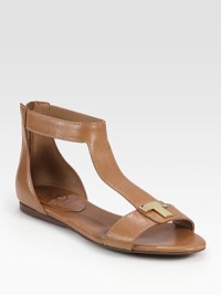 Lustrous leather t-strap with an exposed back zipper and a goldtone T embellishment. Leather upperBack zipperLeather liningRubber solePadded insoleImportedOUR FIT MODEL RECOMMENDS ordering one half size down as this style runs large. Lustrous leather t-strap with an exposed back zipper and a goldtone T embellishment. Leather upperBack zipperLeather liningRubber solePadded insoleImportedOUR FIT MODEL RECOMMENDS ordering one half size down as this style runs large.