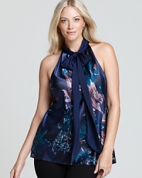 Painterly florals lend artistic inspiration to a fluid Tahari Woman Plus blouse, finished with a halter neckline for feminine allure. Painterly florals lend artistic inspiration to a fluid Tahari Woman Plus blouse, finished with a halter neckline for feminine allure.