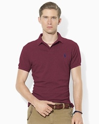 A trim-fitting short-sleeved polo shirt is rendered in breathable cotton mesh with Ralph Lauren's embroidered pony for iconic style. A trim-fitting short-sleeved polo shirt is rendered in breathable cotton mesh with Ralph Lauren's embroidered pony for iconic style.