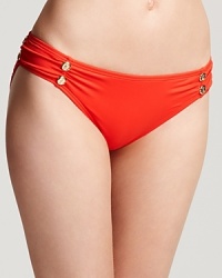 Get a little color with Juicy Couture's cinched bikini bottom. In a vivid orange hue, this style packs a plunge-worthy pop with a sheer chemise and pair of flat sandals.