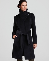 The sculpted silhouette on this Calvin Klein belted coat features a warm funnel neck and tie closure for a cinched waist. The sculpted silhouette on this Calvin Klein belted coat features a warm funnel neck and tie closure for a cinched waist.