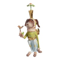 The Pointsittier by Patience Brewster draws his name from the white poinsettia blooms on his pants and the gold-leafed planter sitting on the pup's head. The Pointsittier by Patience Brewster draws his name from the white poinsettia blooms on his pants and the gold-leafed planter sitting on the pup's head.