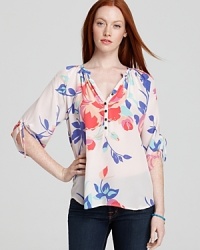 Decorated with a soft floral design and chic ties at the cuffs, this silk Yumi Kim top blooms with femininity. Decorated with a soft floral design and chic ties at the cuffs, this silk Yumi Kim top blooms with femininity.