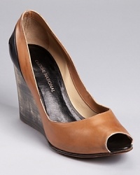 A distressed wooden wedge adds unique appeal to a pair of bi-color wedges from CoSTUME NATIONAL--a black patent panel details the back of this sleek peep toe silhouette. A distressed wooden wedge adds unique appeal to a pair of bi-color wedges from CoSTUME NATIONAL--a black patent panel details the back of this sleek peep toe silhouette.