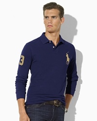 A trim-fitting long-sleeved polo shirt is rendered in breathable cotton mesh with higher armholes and a shorter hem than the classic. A trim-fitting long-sleeved polo shirt is rendered in breathable cotton mesh with higher armholes and a shorter hem than the classic.