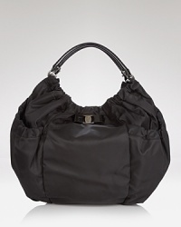 Salvatore Ferragamo makes a casual statement with this spacious nylon hobo. Dressed up in a pretty bow and leather trims, the bag will easily accommodate all your essentials. Salvatore Ferragamo makes a casual statement with this spacious nylon hobo. Dressed up in a pretty bow and leather trims, the bag will easily accommodate all your essentials.