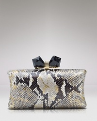 Metallic finished leather meets elegant crystals on this Overture Judith Leiber clutch, which is finished by a geometric bow ornament. Metallic finished leather meets elegant crystals on this Overture Judith Leiber clutch, which is finished by a geometric bow ornament.