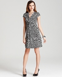 This chic DKNY dress ties together a punchy print and classic silhouette for timeless elegance. This chic DKNY dress ties together a punchy print and classic silhouette for timeless elegance.