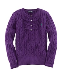 A traditional cable-knit sweater takes a feminine turn with delicate ruffle trim along the buttoned front. A traditional cable-knit sweater takes a feminine turn with delicate ruffle trim along the buttoned front.