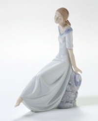 A barefoot young woman, deep in thought, takes a moment to rest on a river bank. Crafted by Lladró, Spain's most esteemed artisans of porcelain figurines. A barefoot young woman, deep in thought, takes a moment to rest on a river bank. Crafted by Lladró, Spain's most esteemed artisans of porcelain figurines.