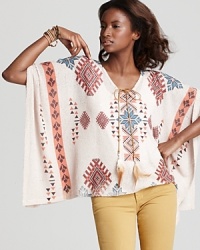 Drawing creative inspiration from a patterned Native American blanket, this Vintage Havana poncho is designed in soft t-shirt material and finished with feather ties. Drawing creative inspiration from a patterned Native American blanket, this Vintage Havana poncho is designed in soft t-shirt material and finished with feather ties.