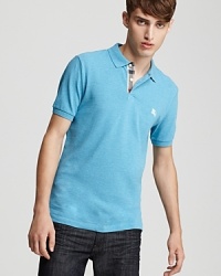 The classic fit polo from Burberry, tastefully accented with a check-lined button placket and embroidered logo. The classic fit polo from Burberry, tastefully accented with a check-lined button placket and embroidered logo.
