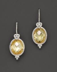 Faceted oval canary crystals, set in sterling silver, are topped with romantic heart detailing. Faceted oval canary crystals, set in sterling silver, are topped with romantic heart detailing.