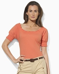 Imbued with breezy bohemian style, a soft cotton jersey top gets a romantic update with a smocked neckline and cuffs. Imbued with breezy bohemian style, a soft cotton jersey top gets a romantic update with a smocked neckline and cuffs.
