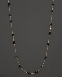 Round and oval black enamel stations and a diamond highlight this gold chain necklace. Round and oval black enamel stations and a diamond highlight this gold chain necklace.