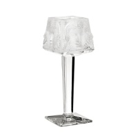 This striking handcrafted candleholder features a fresh interpretation of Lalique's iconic face design in alluring frosted crystal. A single votive (sold separately) illuminates it from within. This striking handcrafted candleholder features a fresh interpretation of Lalique's iconic face design in alluring frosted crystal. A single votive (sold separately) illuminates it from within.