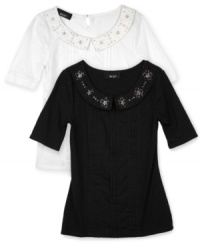 A graceful pleated shirt from BCX is finished with a beaded necklace accent along the neckline for a perfectly pretty look. A graceful pleated shirt from BCX is finished with a beaded necklace accent along the neckline for a perfectly pretty look.