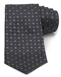 A silk tie adds distinction to your formal presentation. With a repeating pattern of Gancini logos, you'll also punch up your attire with the designer's signature flair. A silk tie adds distinction to your formal presentation. With a repeating pattern of Gancini logos, you'll also punch up your attire with the designer's signature flair.