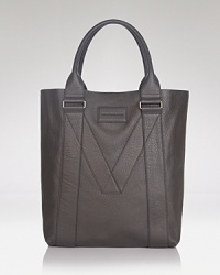 With a signature M deftly patterned into its construction, this tote offers designer appeal in immaculately refined leather. The perfect accompaniment for your travels to and from work and day trips downtown. With a signature M deftly patterned into its construction, this tote offers designer appeal in immaculately refined leather. The perfect accompaniment for your travels to and from work and day trips downtown.