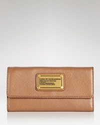 Rich leather is dressed up with a bold logo-stamped plaque in this utility chic wallet from MARC BY MARC JACOBS.