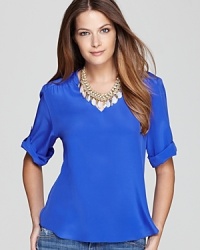 Simple and sleek, this fluid silk Amanda Uprichard top is designed with an elegant v neck and button-up sleeves. Simple and sleek, this fluid silk Amanda Uprichard top is designed with an elegant v neck and button-up sleeves.