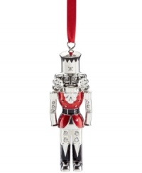 A classic symbol of Christmas re-purposed for your tree, the Lenox nutcracker ornament glistens in polished silver plate with sparkling rhinestone and holiday-red accents. A classic symbol of Christmas re-purposed for your tree, the Lenox nutcracker ornament glistens in polished silver plate with sparkling rhinestone and holiday-red accents.