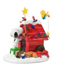 Even Snoopy's dog house is the picture of holiday fun in Peanuts Village. A strand of colorful Christmas lights, red bow and gold star make it a destination for warm and fuzzy holiday moments. Even Snoopy's dog house is the picture of holiday fun in Peanuts Village. A strand of colorful Christmas lights, red bow and gold star make it a destination for warm and fuzzy holiday moments.