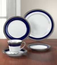 Formal white fine china displays a dramatic combination of scrolling leaves on shimmering platinum and an inner band of intense cobalt blue. Dishwasher safe. Formal white fine china displays a dramatic combination of scrolling leaves on shimmering platinum and an inner band of intense cobalt blue. Dishwasher safe.