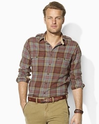 Ideal as a layering piece or perfectly rugged on its own, this trim-fitting military shirt is rendered from supremely soft flannel in a classic plaid print. Ideal as a layering piece or perfectly rugged on its own, this trim-fitting military shirt is rendered from supremely soft flannel in a classic plaid print.