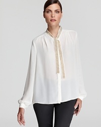 The essential white shirt goes contemporary cool as a shimmering tie neckline and sheer silhouette inspire this VINCE CAMUTO blouse. Team with sleek leather leggings for sophisticated edge. The essential white shirt goes contemporary cool as a shimmering tie neckline and sheer silhouette inspire this VINCE CAMUTO blouse. Team with sleek leather leggings for sophisticated edge.