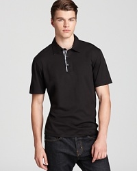 The contrast trim at the placket is excitingly offset by the gingham check underneath for an unexpected 1-2 polo punch from Michael Kors. The contrast trim at the placket is excitingly offset by the gingham check underneath for an unexpected 1-2 polo punch from Michael Kors.