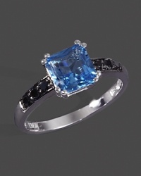 Black diamonds accent a faceted blue topaz set in 14K white gold. Black diamonds accent a faceted blue topaz set in 14K white gold.