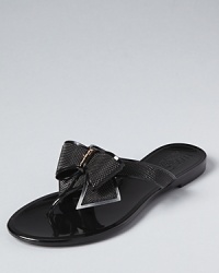 A dramatic, textured bow rests at the front of a dressed-up flip flop sandal from Salvatore Ferragamo. A dramatic, textured bow rests at the front of a dressed-up flip flop sandal from Salvatore Ferragamo.